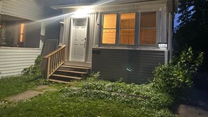 Una casa de dos pisos con un porche delantero, una escalera que conduce a la puerta y el número 708 en la pared frontal.