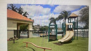 A playground with a slide, climbing structures, and a swing set.