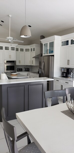 Enjoy cooking in this well-equipped kitchen with a central island, refrigerator, oven, and microwave.