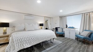 Een moderne hotelkamer met een groot bed, nachtkastjes, een bureau en een stoel.