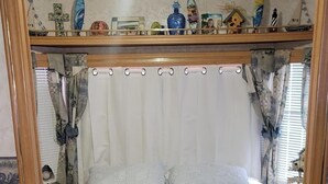 A bedroom with a bed, curtains, and a wooden floor. - Key Largo Relaxing Gataway with Stoning Sunsets Views (Key Largo)
