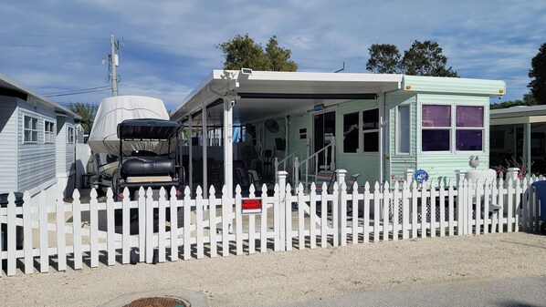 A mobile home with a covered porch and a white picket fence. - Key Largo Relaxing Gataway with Stoning Sunsets Views (Key Largo)