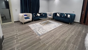A modern living room with two sofas, a coffee table, and a patterned rug. - Premier Pyramids Inn (Giza)