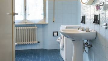 Een bad/douchecombinatie, een bidet, handdoeken