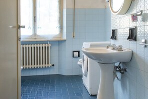 Een bad/douchecombinatie, een bidet, handdoeken