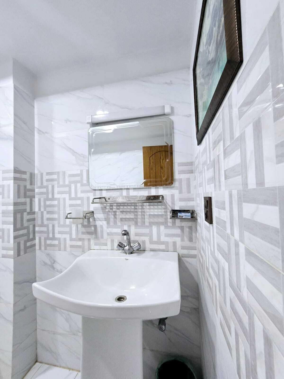 A bathroom with a white sink, a mirror, and a towel rack.