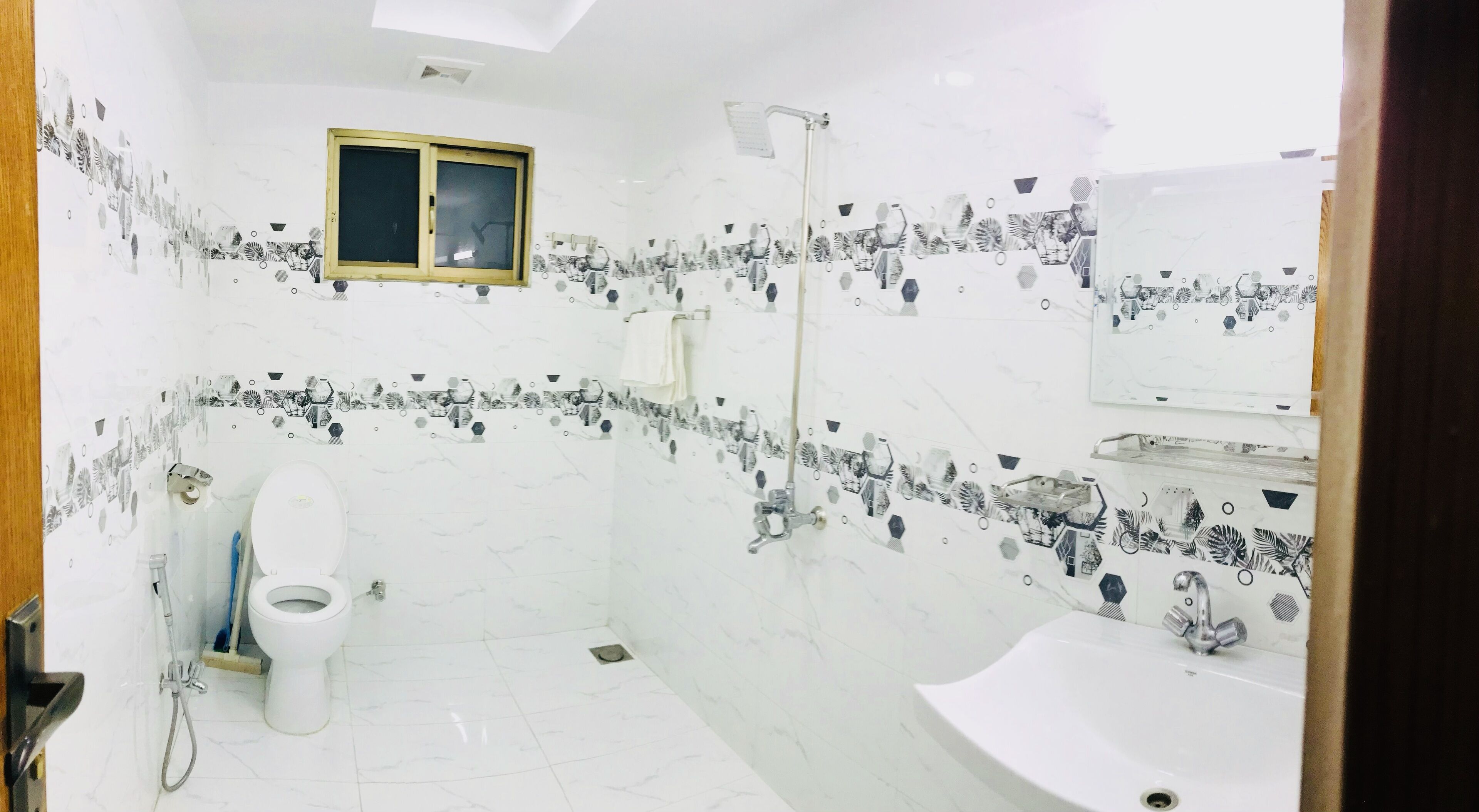A bathroom with a toilet, shower, and sink.