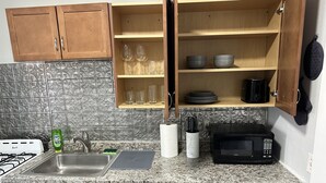 Une cuisine dotée de plans de travail en granit, d’une cuisinière, d’un évier et d’armoires en bois.