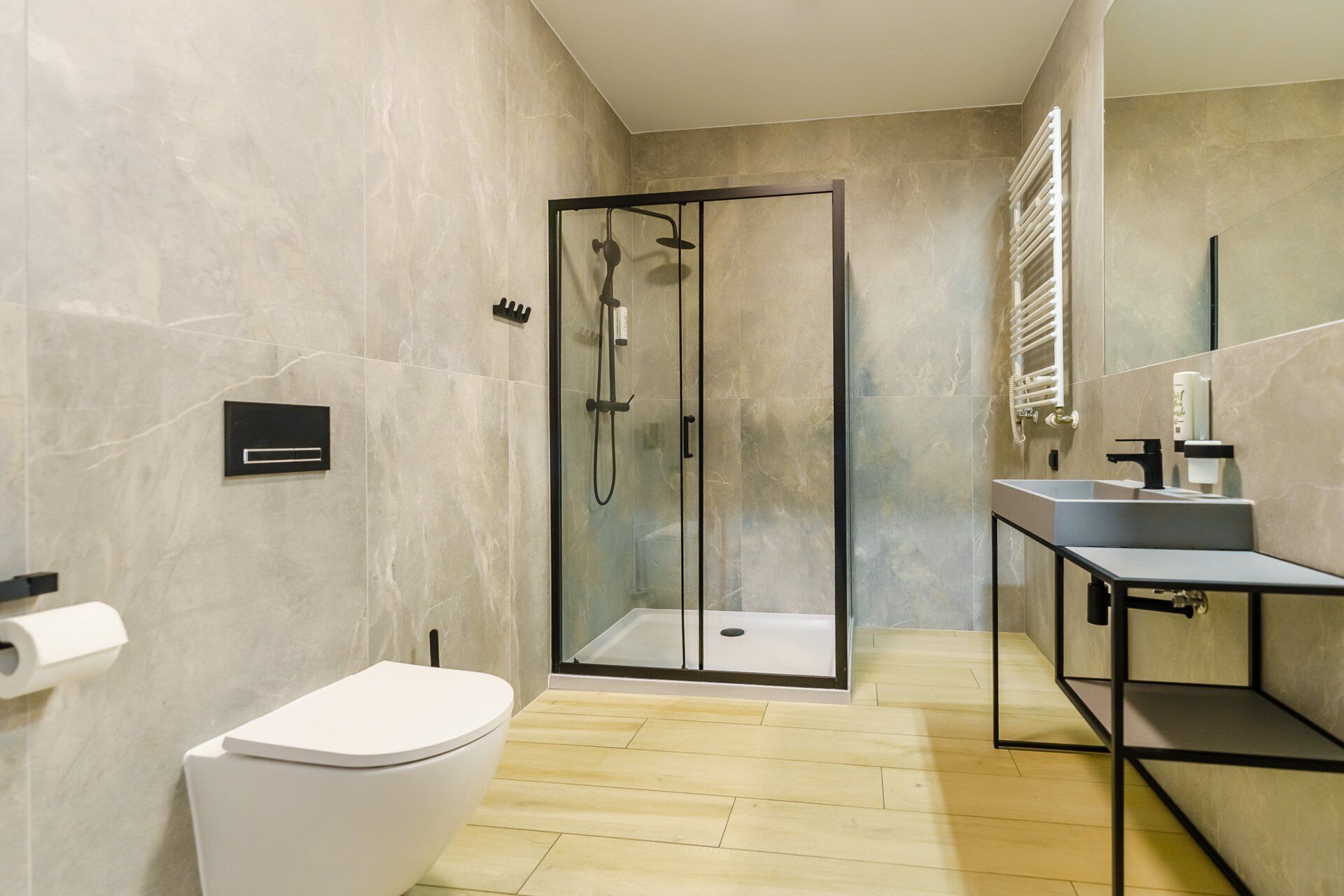 Une salle de bain moderne avec une douche à parois de verre, des toilettes et un lavabo avec un miroir.