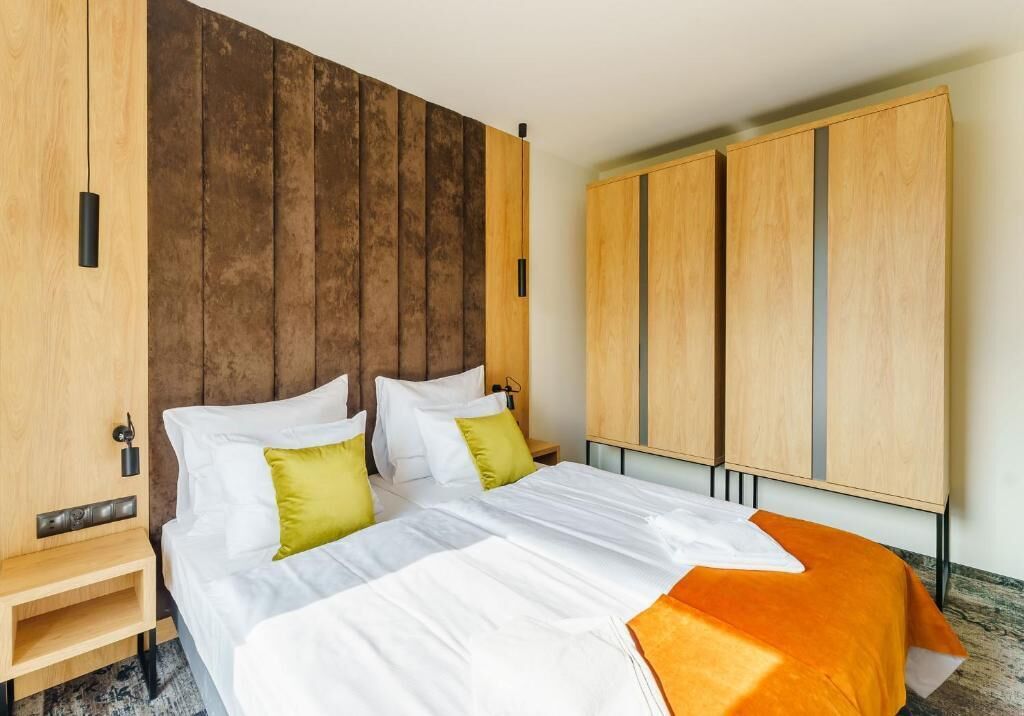 A hotel room with a bed, wooden headboard, and a wardrobe.