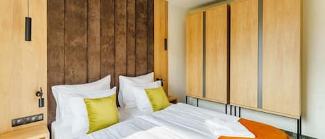 A hotel room with a bed, wooden headboard, and a wardrobe.