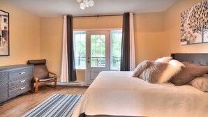 A bedroom with a bed, a dresser, a chair, and a painting on the wall. - Luxury 2 bedroom, 2 bath condo , 2 balconies, hi speed WIFI with FREE parking (Montréal)