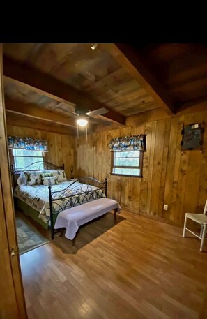 Cozy bedroom with a bed, sloped ceiling, and exposed beams.
