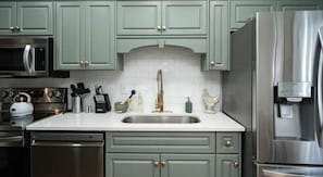 Enjoy cooking in this well-equipped kitchen with a stainless steel refrigerator, oven, and double sink.