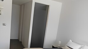 Un dormitorio moderno con cama, mesita de noche y armario.