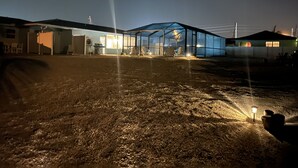 A greenhouse structure with a glass roof, surrounded by a gravel driveway and adjacent buildings. - CLEAN,Great Location,Dockage Available,HEATED Pool, HUGE Back yard. Unit C  (Englewood)