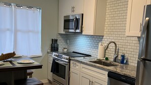 A modern kitchen with white cabinets, a stainless steel refrigerator, a microwave, and a dishwasher. - CLEAN,Great Location,Dockage Available,HEATED Pool, HUGE Back yard. Unit C  (Englewood)