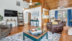A spacious living room with a wooden ceiling, a television, a coffee table, and a leather sofa. - Bass Lake Cabin—Game Room—BBQ—5:4—Boat Slip (Bass Lake)