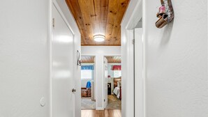 A hallway with wooden floors, white walls, and a ceiling with exposed beams. - Bass Lake Cabin—Game Room—BBQ—5:4—Boat Slip (Bass Lake)
