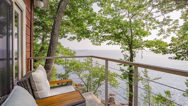 Un balcon doté de meubles en osier et offrant une vue sur la mer.