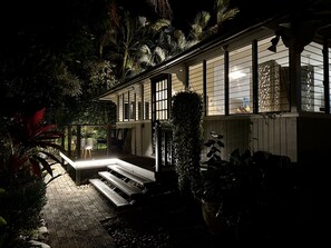 A house with a covered porch, a staircase leading to the entrance, and a variety of plants around the property. - Sweet Creek Cottage, Palm Cove (Palm Cove)