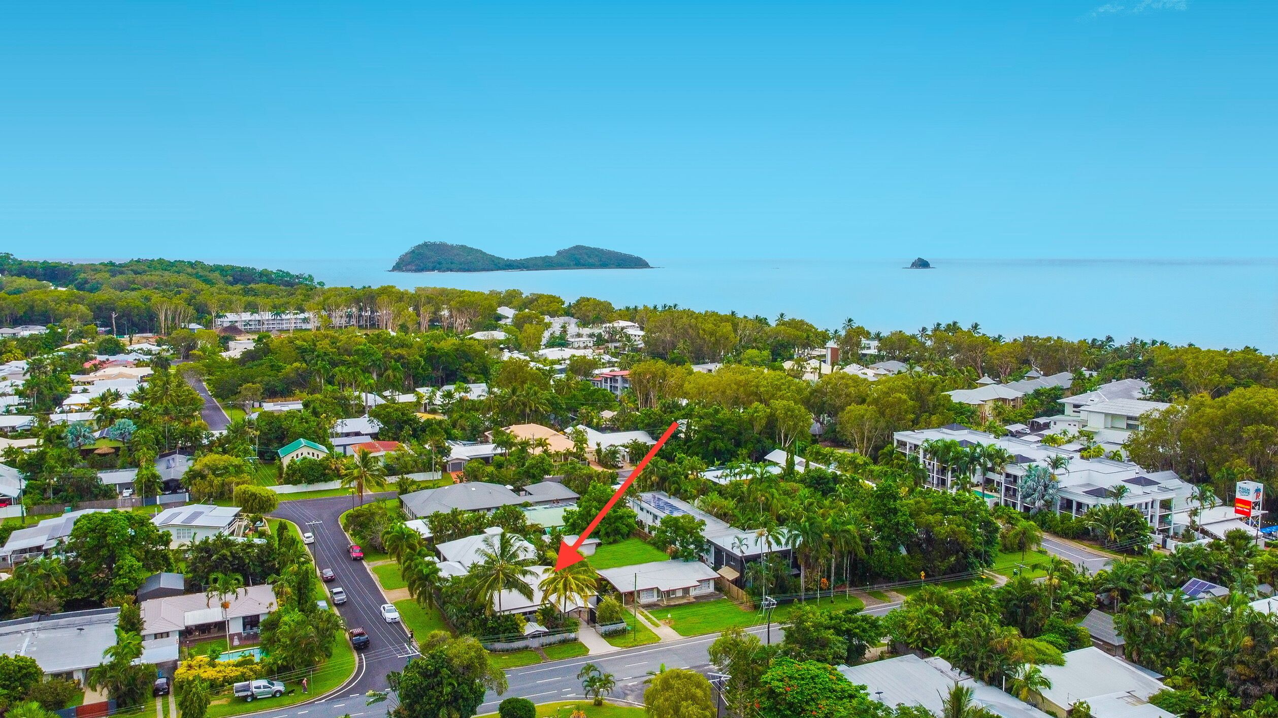 A residential area with houses, roads, and a large body of water in the background.