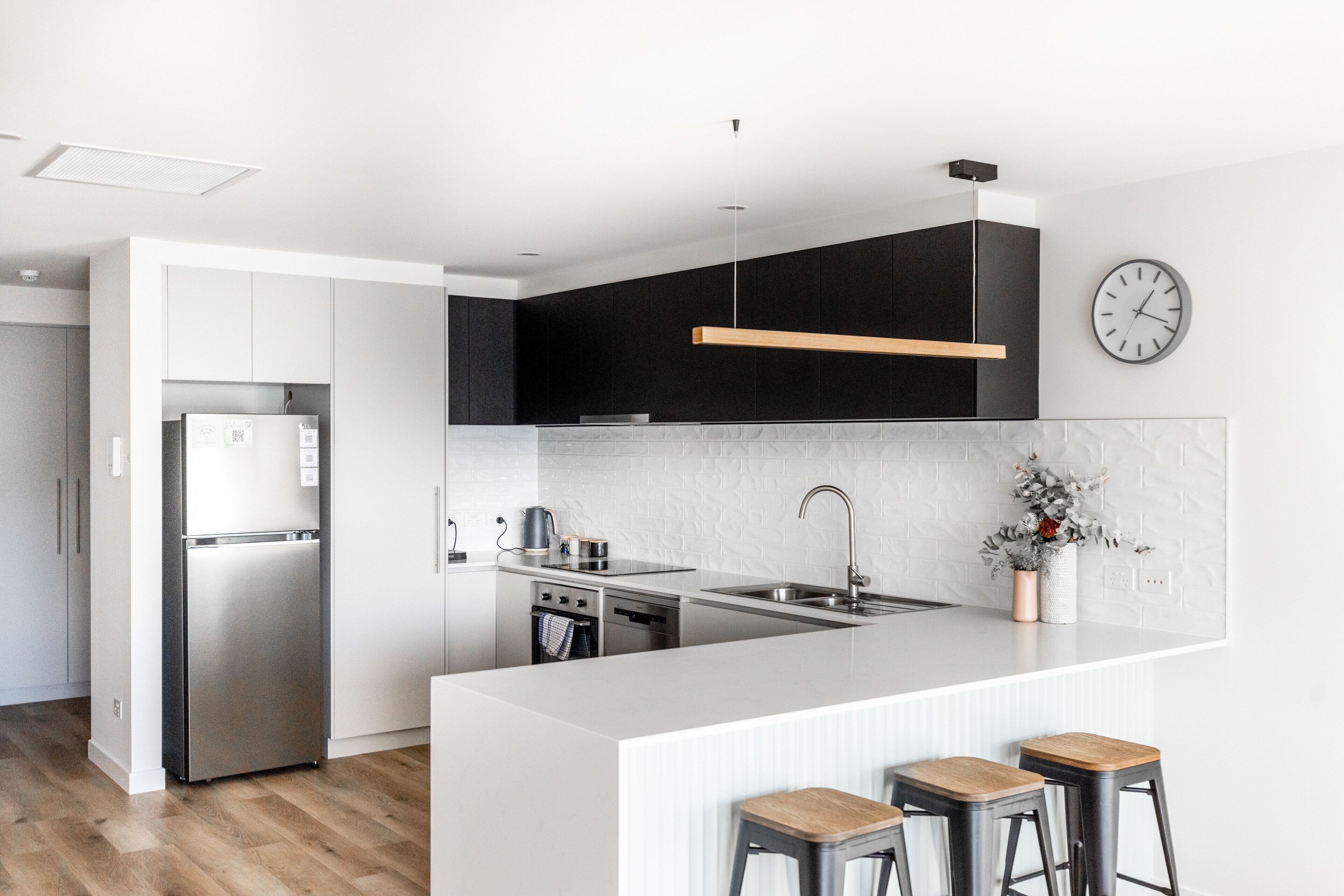 Una cocina moderna con una isla central, electrodomésticos de acero inoxidable y un diseño minimalista.