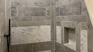 A shower with a herringbone tile pattern and a wooden ceiling. - Gunner's Goat House at Billy Goat Mountain Village (Williamson)
