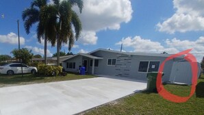 Una casa moderna de dos pisos con un amplio camino de entrada, un garaje y un césped bien cuidado.