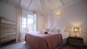 A bedroom with a bed, bedside table, and a window with curtains.