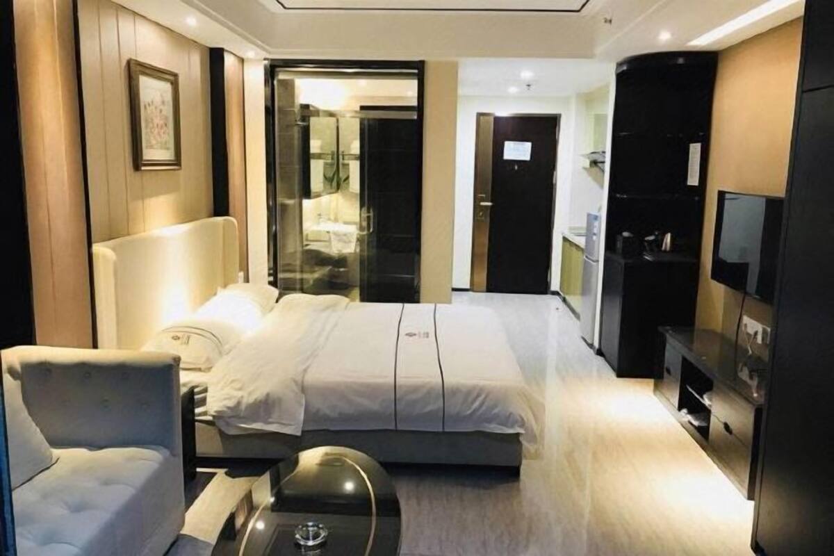 Een moderne hotelkamer met een bed, een stoel, een bureau en een televisie.