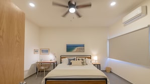 A bedroom with a bed, a desk, a chair, a ceiling fan, and a wall-mounted air conditioner. - Casa La Paz with pool, patio and bbq grill (La Paz)