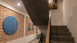 A staircase with a modern design, a brick wall with artwork, and a potted plant. - Casa La Paz with pool, patio and bbq grill (La Paz)