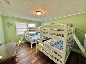 A child's bedroom with bunk beds, a window with blinds, a small table, and a wall-mounted shelf. - The Reef Apartments Unit #2 - Downtown/5min walk to the beach! (Ocean City)