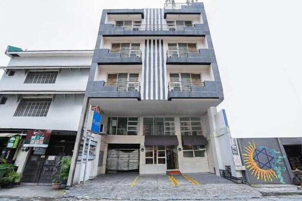 A multi-story building with a central entrance, balconies, and a ground-level shop. - Alley 8 Makati (Makati)