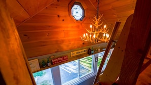 A wooden interior with a chandelier, a sign for Redneck Nightclub, and a window view.