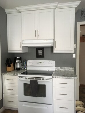 Enjoy cooking in this well-equipped kitchen with a digital stove, coffee maker, and ample countertop space.