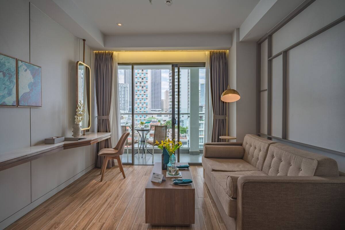 Una sala de estar moderna con sofá, mesa de centro y un comedor con mesa y sillas.