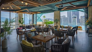 Un espacio interior moderno con techos altos, vigas de madera y grandes ventanales que ofrecen vistas a la ciudad.