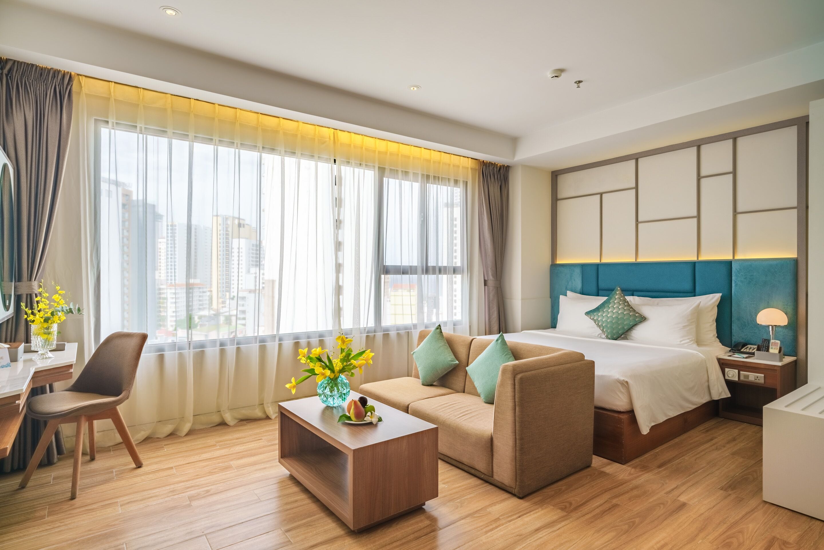 Une chambre d’hôtel moderne équipée d’un grand lit, d’un canapé, d’une table basse et d’un bureau.