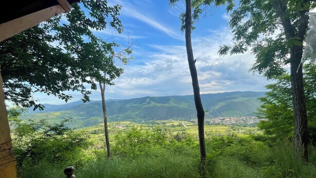 Un banco con vistas a un valle pintoresco y una vista despejada del pueblo.