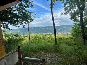 A bench overlooking a scenic valley with a clear view of the town below. - Mountain House in Bulgaria historic village in Rose Valley (Klisura)