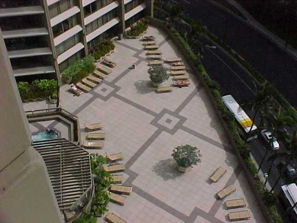 A courtyard with outdoor seating, a staircase, and a road adjacent to the building.