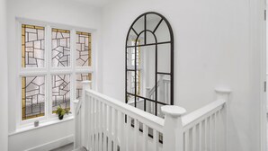 A staircase with white railings and a black metal arch window. - BIG House Free Parking Walking Distance to Kensal Rise Station (London)
