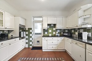 Kitchen features an oven, microwave, and sink with a small window above.