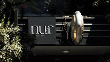 A hotel sign with a modern design, a visible number '8' indicating a floor or section, and a partial view of the building's entrance.
