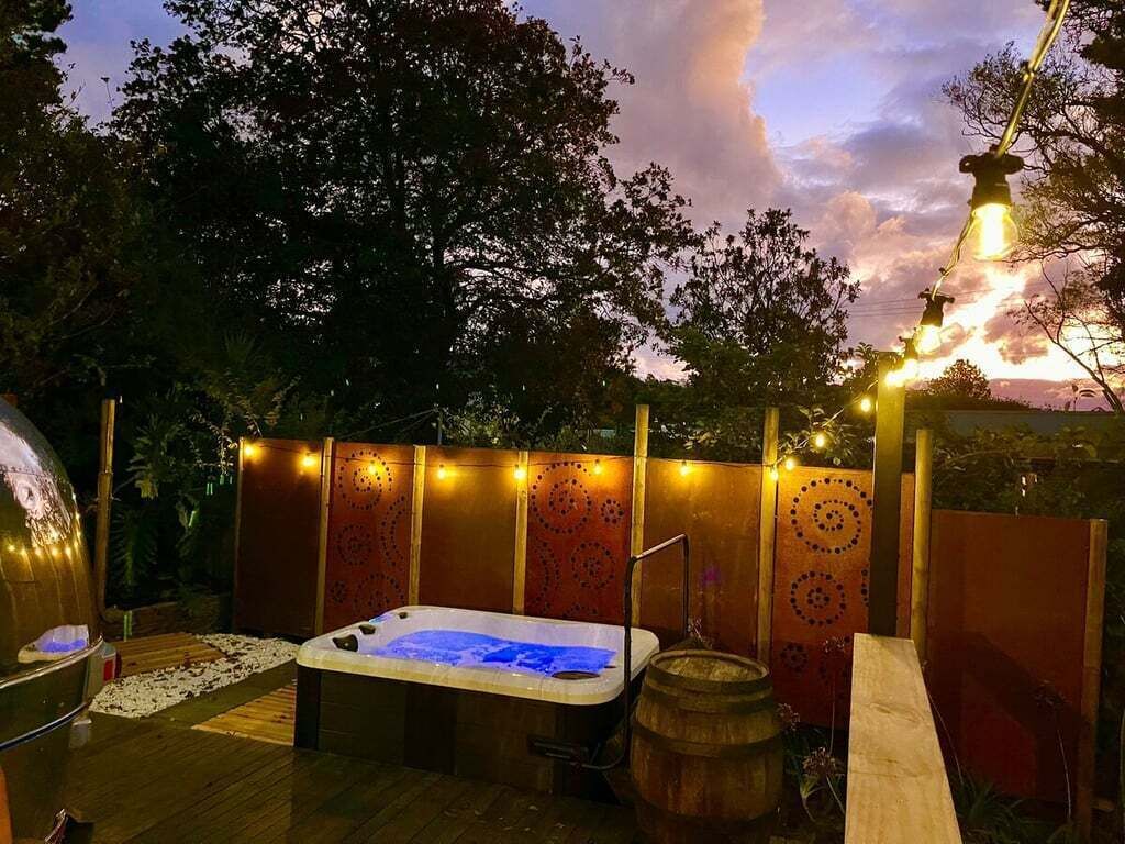 Tinaco, terraza de madera y luces decorativas en un entorno exterior.