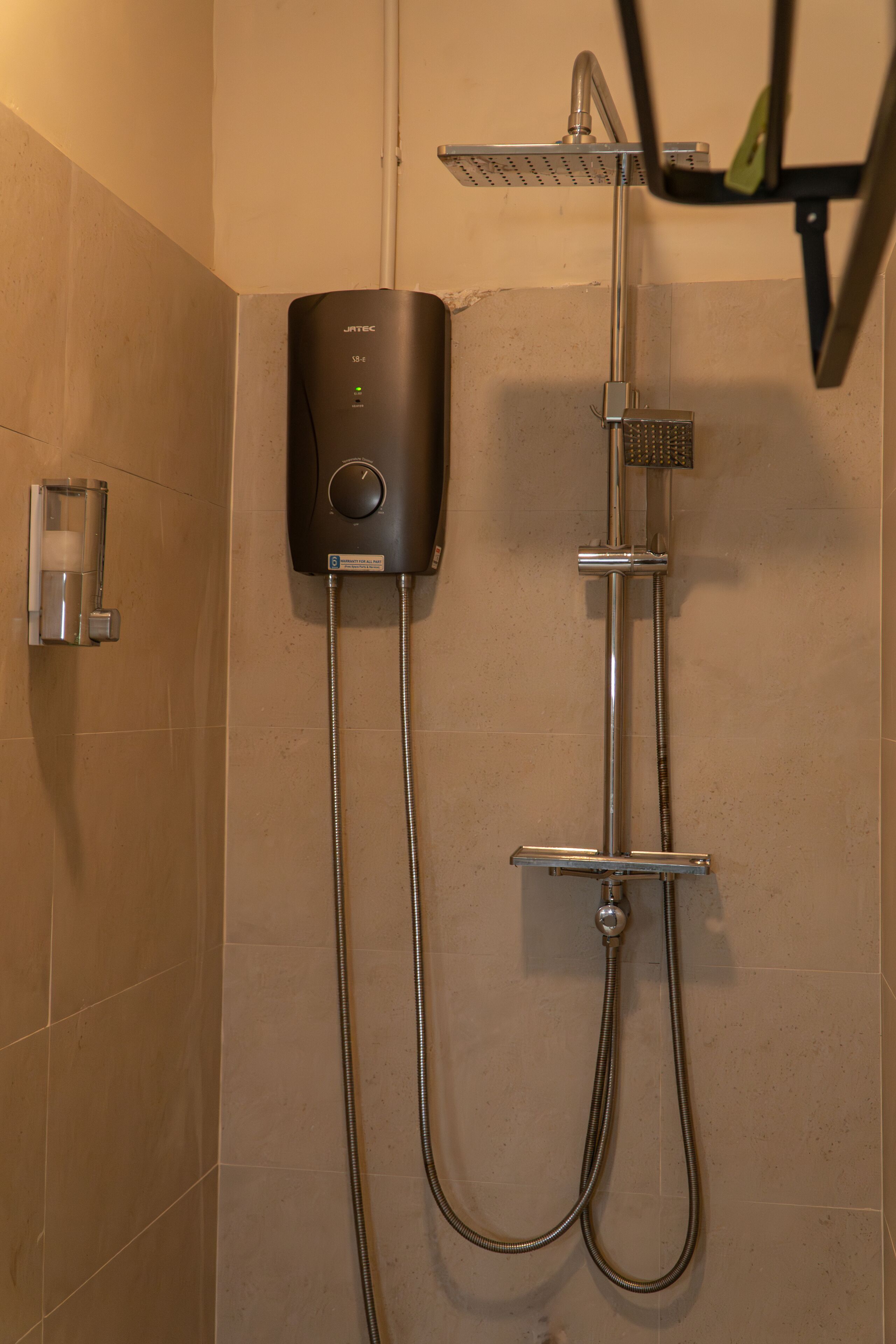A modern shower with a handheld showerhead and a wall-mounted control panel.