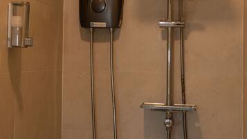 A modern shower with a handheld showerhead and a wall-mounted control panel.