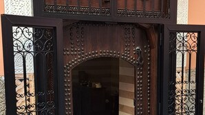 A wooden entrance with intricate metalwork and a tiled floor. - Riad parfum d'orient (Marrakech)